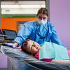 A young patient smiles while receiving dental care from a Kornberg School of Dentistry dentist