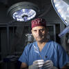 Riyaz Bashir, wearing scrubs and holding his life-saving medical innovation.